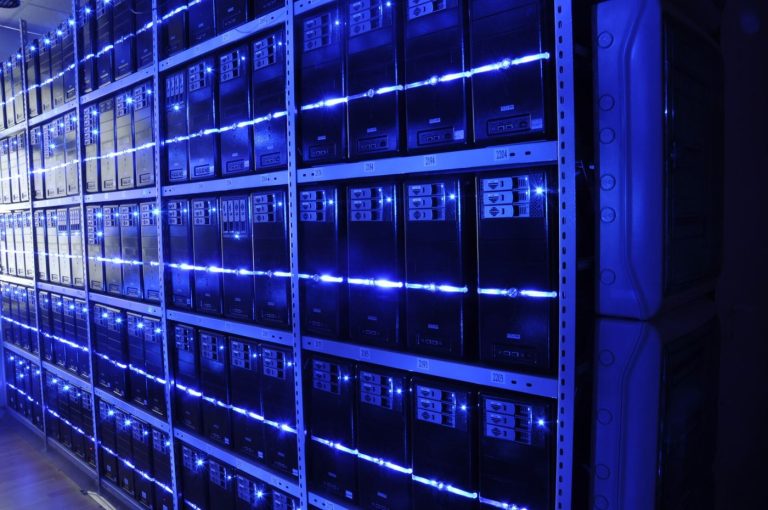 Data Centers Test New Cooling Methods to Save Energy engineer inspecting server racks inside large data center